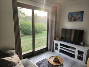 a living room with a tv and a large window at Santika Sunhill Cottage in Stellenbosch