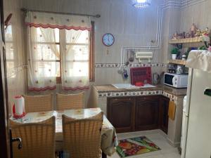 a kitchen with a table and chairs and a clock on the wall at Location appartement Oran Akid lotfi in Oran