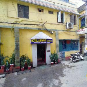 un bâtiment jaune avec un panneau indiquant les animaux de l'hôtel dans l'établissement Rose Premium Studio Apartment by Hotel Airways, à Kolkata