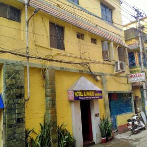 un bâtiment jaune avec un panneau à l'avant dans l'établissement Rose Premium Studio Apartment by Hotel Airways, à Kolkata