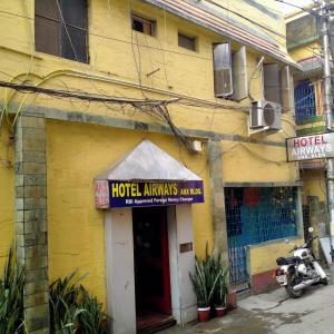um edifício amarelo com um letreiro de hotelamines em Rose Premium Studio Apartment by Hotel Airways em Calcutá
