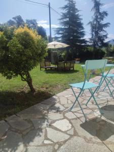 einen blauen Stuhl, einen Tisch und einen Regenschirm in der Unterkunft Il Rio Grande in Beverino