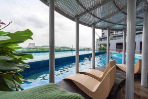 a swimming pool with chairs and people in the water at Simfoni Tower 3R2B 8pax @C180@Chr Trader Square in Seri Kembangan