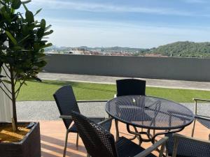 a table and chairs on a balcony with a view of a field at Simfoni Tower 3R2B 8pax @C180@Chr Trader Square in Seri Kembangan