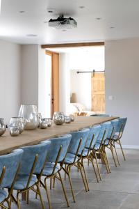 una mesa larga con sillas azules en una habitación en 't Hooiland, en Lo-Reninge