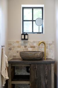 baño con lavabo de piedra y ventana en 't Hooiland, en Lo-Reninge