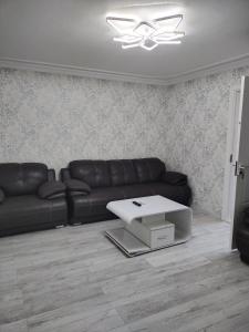 a living room with a black leather couch and a table at Амид 3 in Khujand
