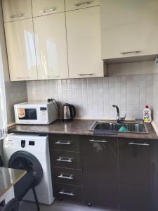 a kitchen with a sink and a microwave at Амид 3 in Khujand