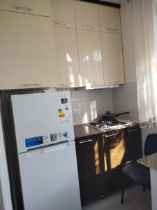 a kitchen with a white refrigerator and a stove at Амид 3 in Khujand
