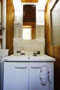 y baño con lavabo blanco y espejo. en The LODGE ABASHIRI en Abashiri