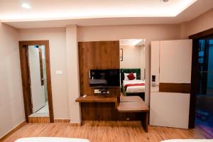Cette chambre comprend un miroir, un lit et un lavabo. dans l'établissement HOTEL JSR GANGA, à Varanasi