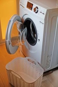 a washing machine sitting next to a laundry basket at The LODGE ABASHIRI in Abashiri