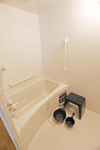 Un baño con lavabo y bañera. en The LODGE ABASHIRI, en Abashiri