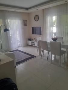 a living room with a table and chairs and a television at Konyaaltı Denize Yakın Kiralık Daire in Antalya