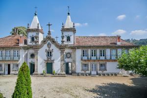 een groot wit gebouw met twee torens bij Outeiro Tuías - Manor House in Marco de Canavezes