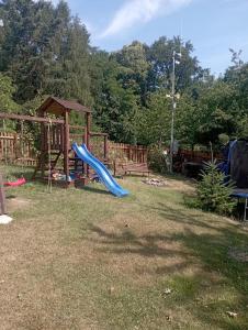 a playground with a blue slide in a yard at Hospůdka Na Trucovně in Sázava