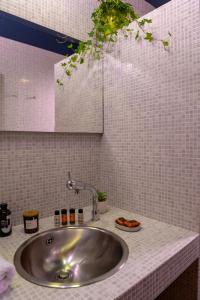 een wastafel in een badkamer met witte tegels bij Red Castle in Souda