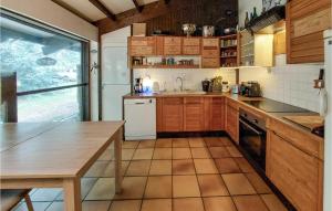 uma cozinha com armários de madeira, uma mesa e um balcão em 4 Bedroom Beautiful Home In Mrignac em Mérignac