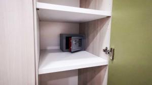 a room with a small microwave in a closet at Kris Luxury Apartments in Giardini Naxos