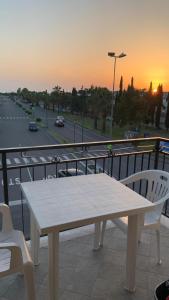 un tavolo bianco e sedie su un balcone con vista sul tramonto di Casa vacanza, 200 m dal mare a Scalea