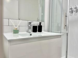 a white bathroom with a sink and a shower at Brand New & Ready for You! By KOSH BNB in Hamilton