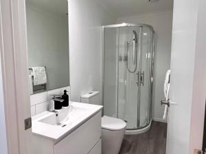 a bathroom with a shower and a toilet and a sink at Brand New & Ready for You! By KOSH BNB in Hamilton