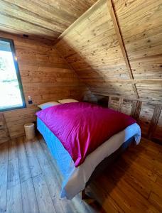 a bedroom with a bed in a wooden cabin at Chalet Vieux Bois, au coeur du village des Rousses in Les Rousses