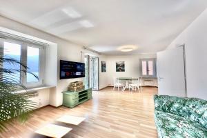 Casa al Lago Apartments - Brissago Experience في بريساغو: غرفة معيشة مع أريكة وطاولة