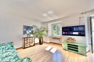 un soggiorno con divano e TV di Casa al Lago Apartments - Brissago Experience a Brissago