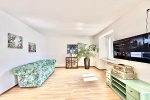 Casa al Lago Apartments - Brissago Experience في بريساغو: غرفة معيشة مع أريكة وتلفزيون بشاشة مسطحة