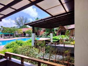 a patio with a table and a swimming pool at D.R. Lanta Bay Resort in Ko Lanta