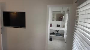 sala de estar con TV de pantalla plana en la pared en Pieds dans l'eau Private Wellness Bordure de Meuse en Lustin