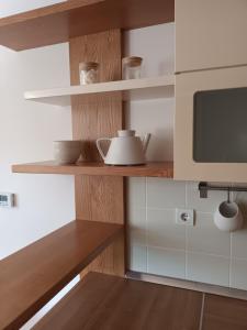 a kitchen with wooden shelves and a microwave at City Nest Apartment in Kobarid