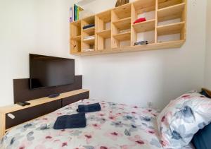 a bedroom with a bed and a flat screen tv at Le NID du STADE de FRANCE in Saint-Denis