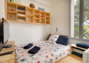 um quarto com uma cama com almofadas em Le NID du STADE de FRANCE em Saint-Denis