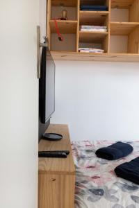 um quarto com uma secretária, uma televisão e um computador em Le NID du STADE de FRANCE em Saint-Denis