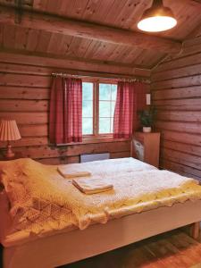 ein Schlafzimmer mit einem Bett in einem Holzzimmer in der Unterkunft Unique farm stay in the steep mountains of Rjukan 