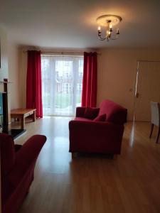 a living room with a couch and red curtains at Community Courtyard Bungalow Apt in Drogheda