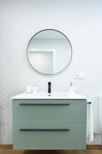 a bathroom with a white sink and a mirror at Zalaeta Playa Apartments in A Coruña