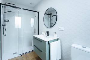 a bathroom with a sink and a mirror at Zalaeta Playa Apartments in A Coruña