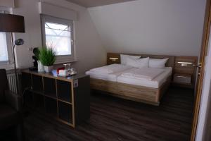 a small bedroom with a bed and a mirror at Pension Julia 2 in Norden
