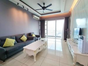 a living room with a blue couch and a tv at Johor Bahru Luxury Pinnacle Tower 3 Bed 2 Bath in Johor Bahru