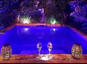 two glasses of wine sitting next to a swimming pool at DDG Retreat in Casares