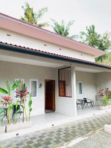 a house with a porch with chairs and tables at Bulan Biru in Kuta Lombok