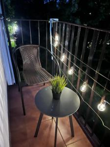 una mesa y una silla en un balcón con luces en Apartament w Zdroju, en Busko-Zdrój