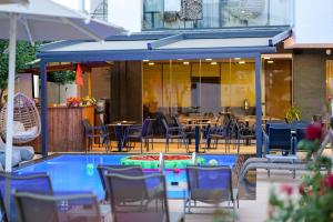 a patio with tables and chairs and a swimming pool at Duka's Hotel in Ksamil