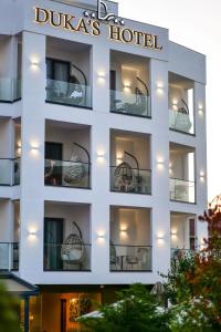 a white building with a hotel sign on it at Duka's Hotel in Ksamil