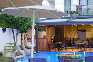 a pool with chairs and a table and an umbrella at Duka's Hotel in Ksamil