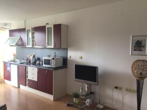 cocina con armarios morados y microondas en Rose Apartment on the Beach, en Byala 9 fotos más