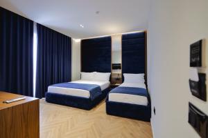a hotel room with two beds and a desk at Duka's Hotel in Ksamil